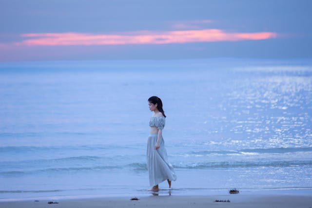 Woman walking along the water